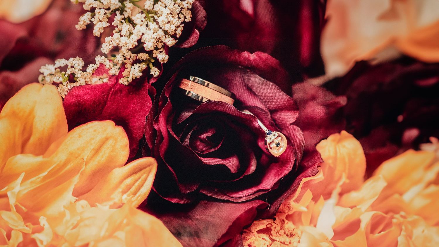 Close-up of burgundy and cream floral wedding decorations with sparkly accents.