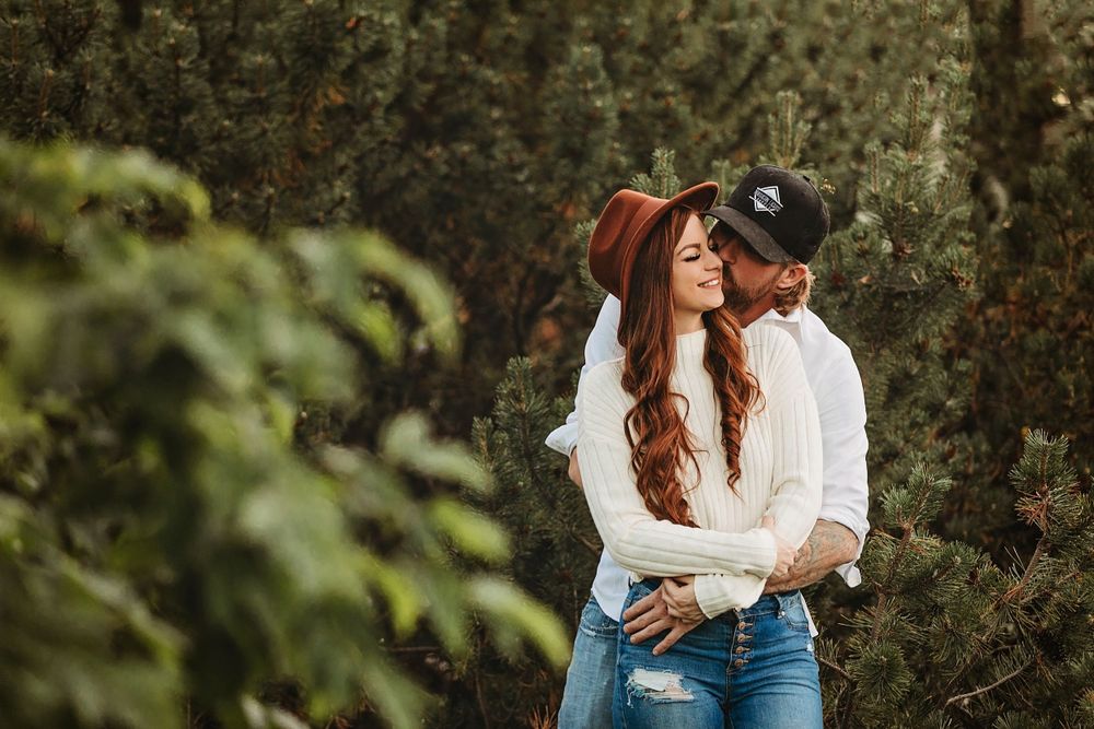 A romantic embrace amidst greenery and natural surroundings.