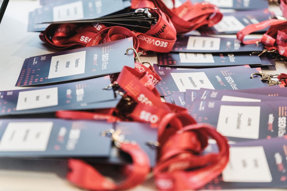 Red conference lanyards and badges laid out on a blue surface.