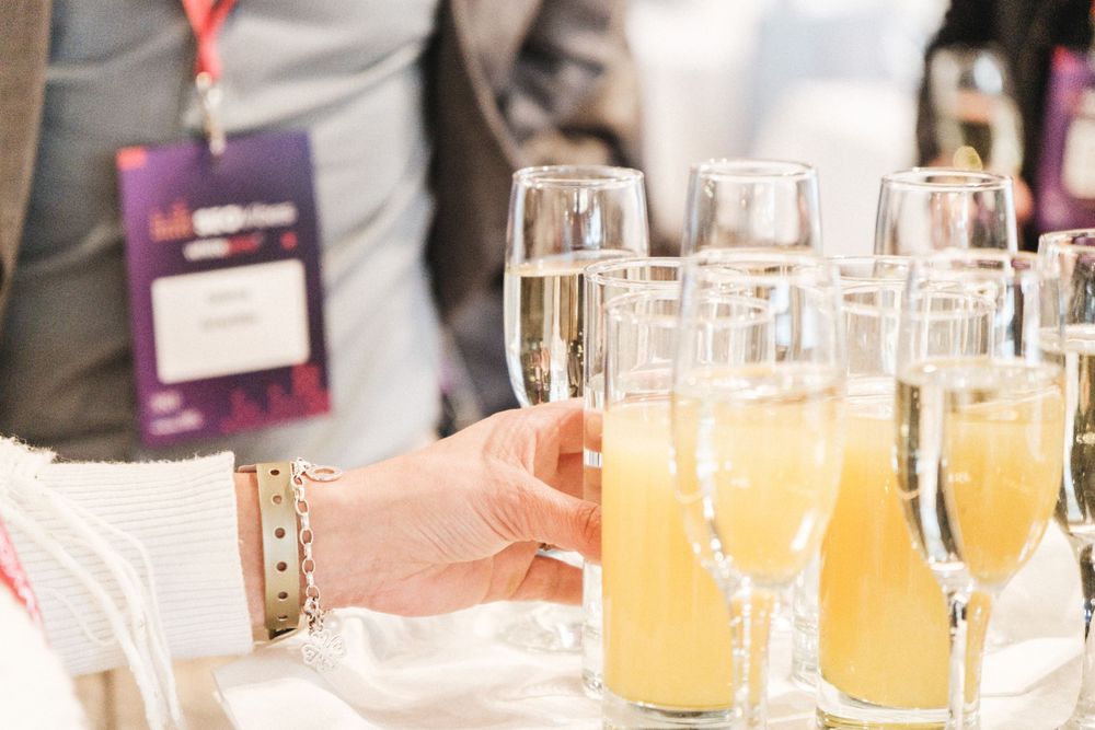 Row of champagne glasses filled with mimosas on an event table.