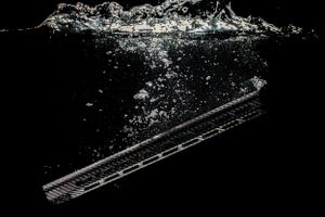 Silhouetted rifle handguard in a tank of water with bubbles