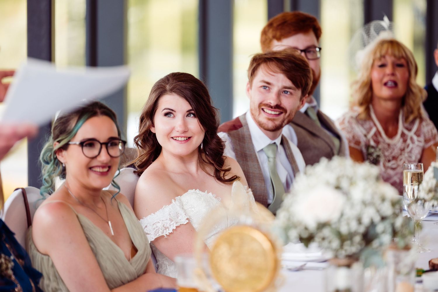 Wedding celebration showing joyful moments during reception speeches.