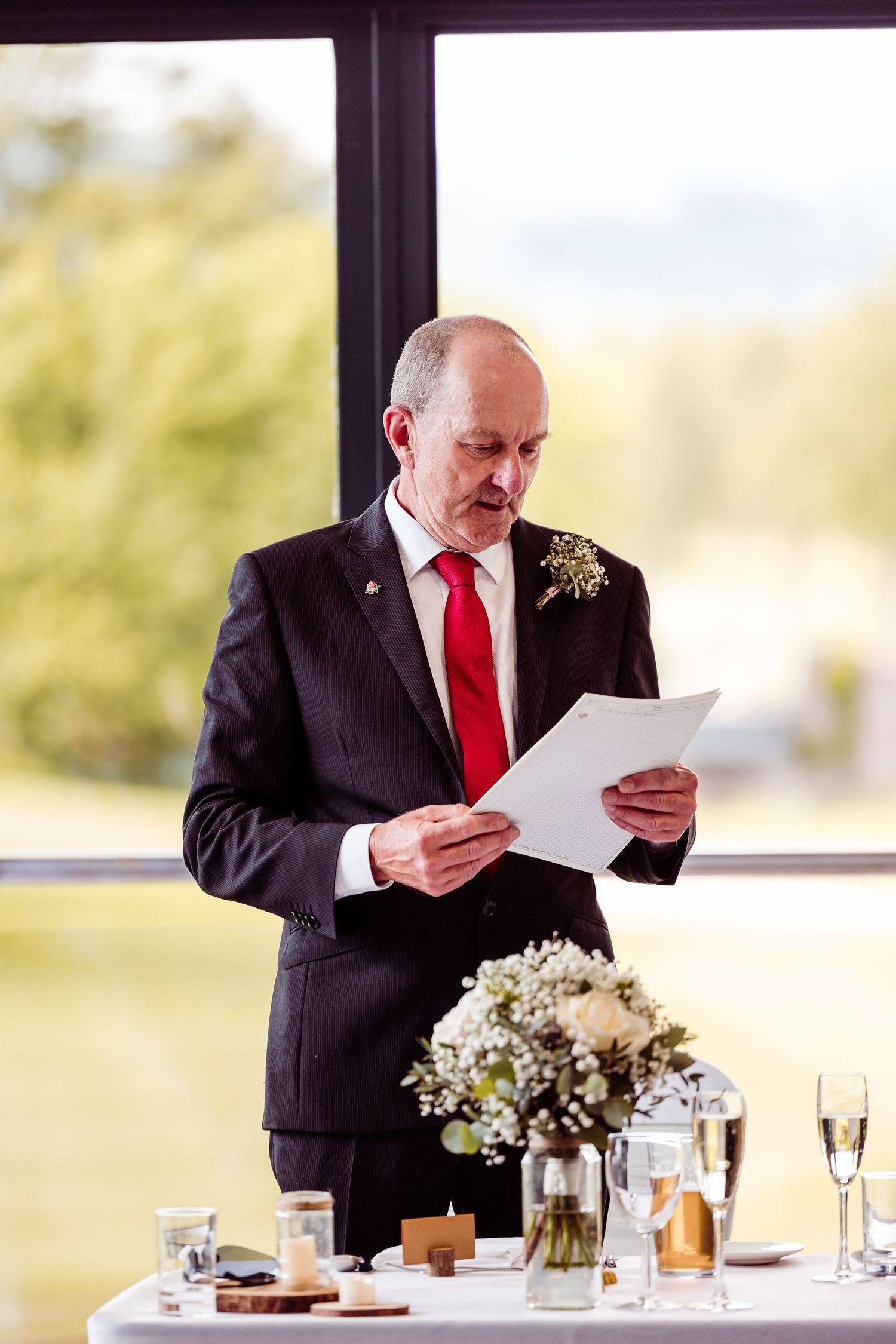Speaker delivering speech at formal event with champagne and table settings.