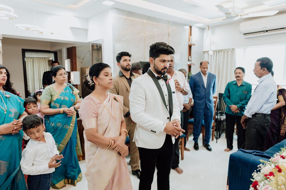 Wedding ceremony scene with traditional Indian attire and white tuxedo in an indoor setting.