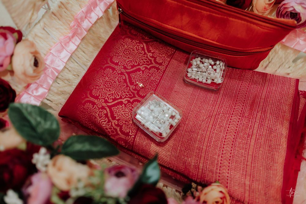 Red silk fabric with ornate embroidery displays wedding jewelry boxes.
