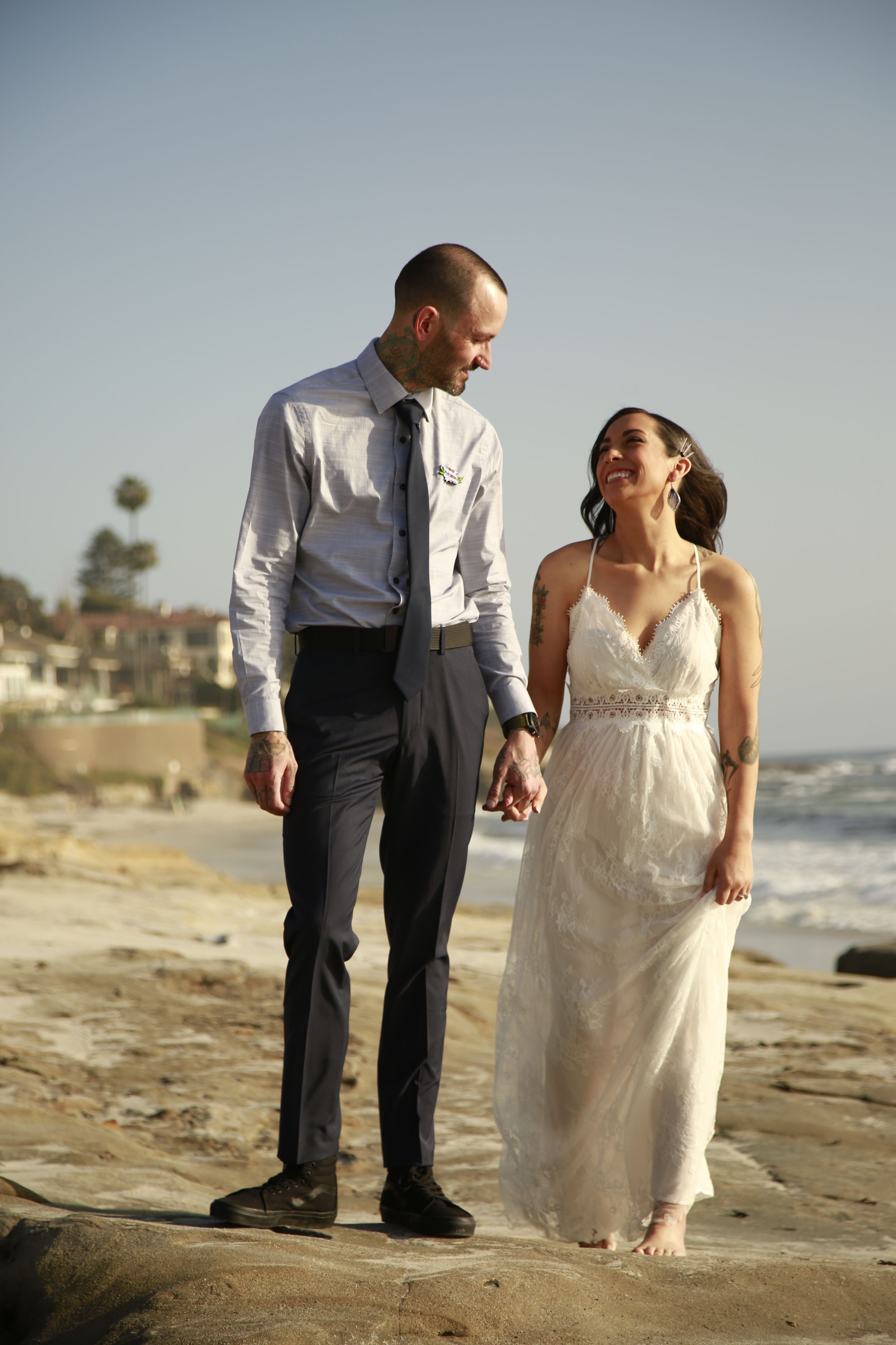 Wedding couple shares intimate moment during beach photoshoot at golden hour.