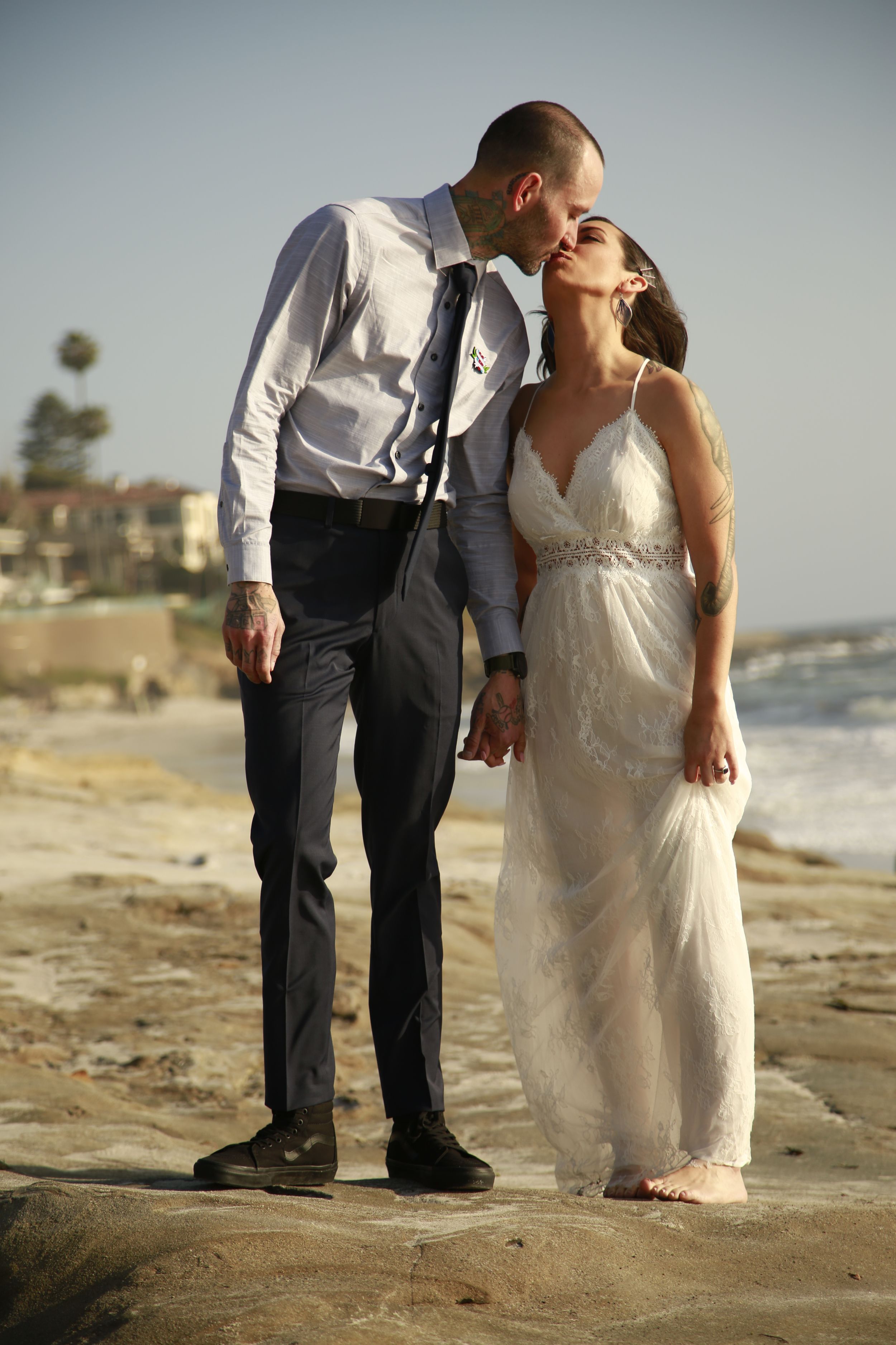 A romantic beach wedding photo with a couple sharing an intimate moment at sunset.