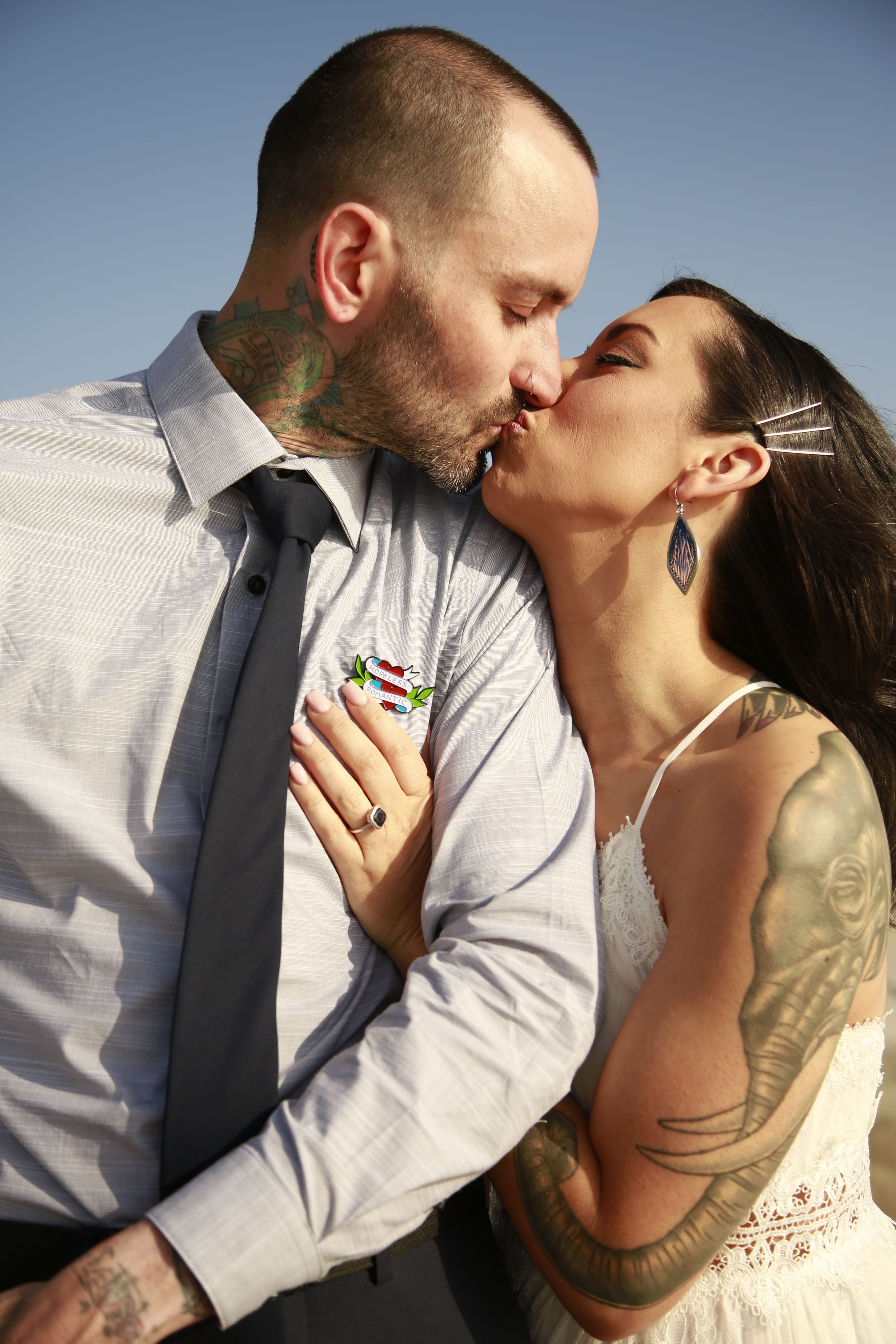 An intimate wedding portrait showing affection between a couple on a coastal backdrop.