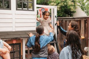 A playful outdoor scene with people lifting someone up in celebration.