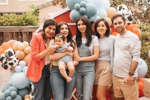 Group gathering at festive outdoor party with balloon decorations and barn theme.