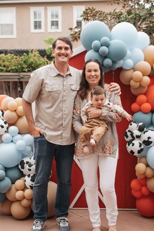 Farm-themed celebration with balloon decorations and red barn backdrop.