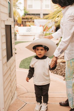 Little ones walking along a sidewalk path during an outdoor party event.
