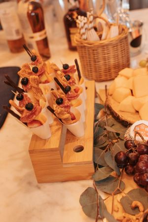 Close-up of appetizers and cheese displayed on wooden boards with decorative garnishes.