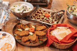 Assorted party foods and appetizers displayed on wooden serving platters at a casual gathering.