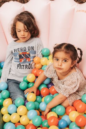 Children play with colorful balloons at what appears to be a birthday party celebration.