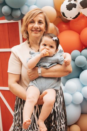 Party scene with balloon arch and decorative background in orange and blue theme.
