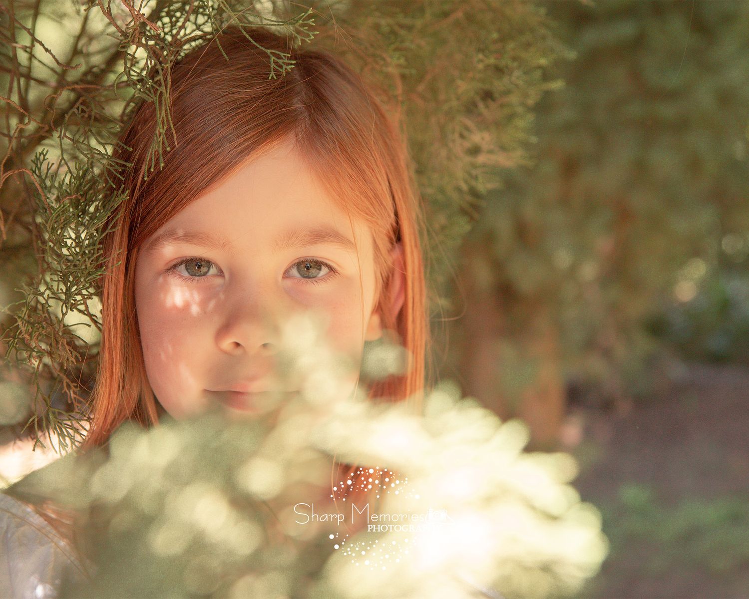 Ethereal portrait through sunlit foliage creating dappled light effect.
