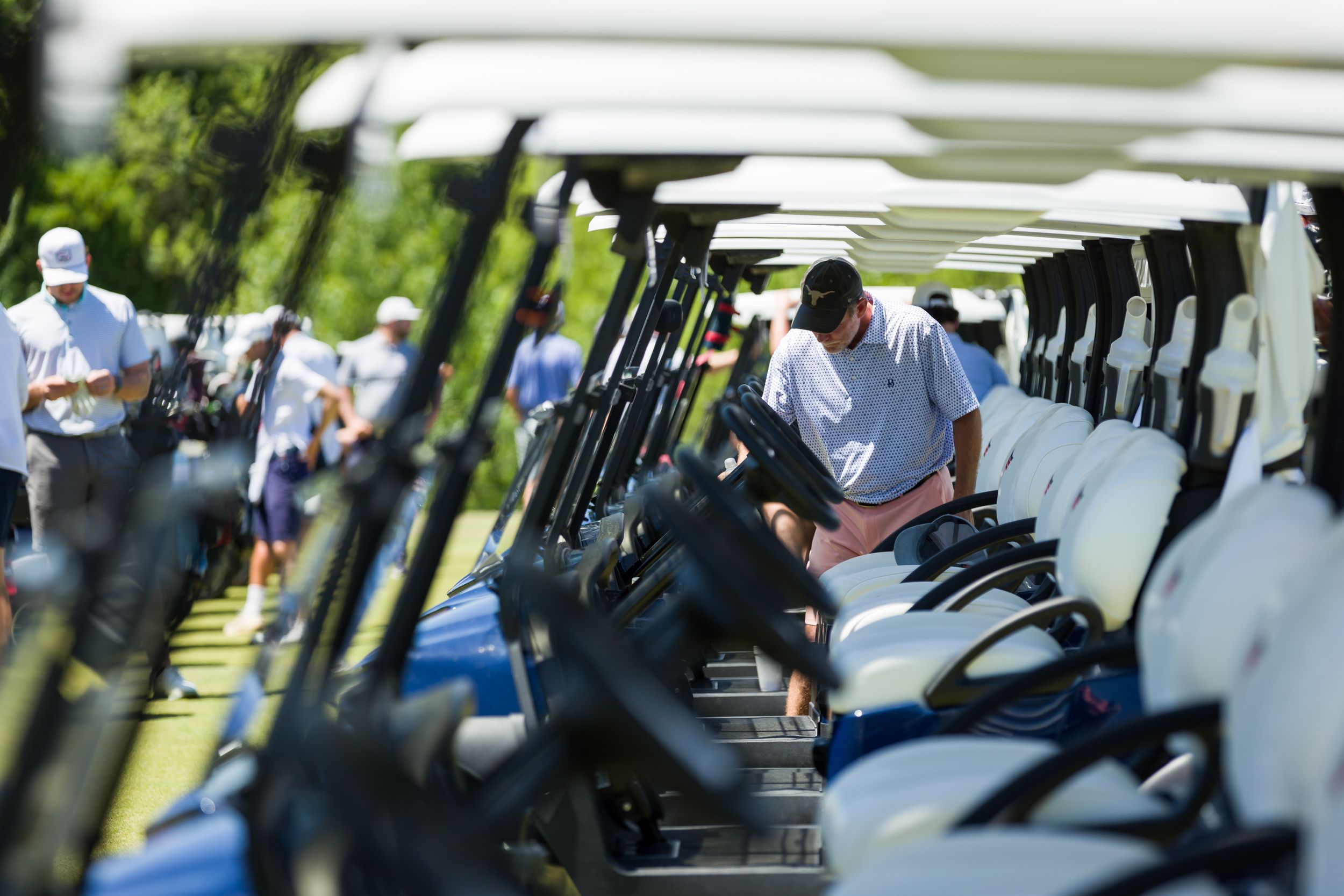 Row of parked golf carts at an outdoor event venue.