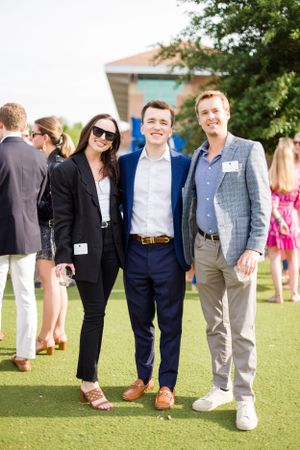Casual group photo showing legs and feet of attendees at an outdoor event.