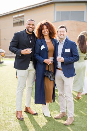 People standing together on artificial turf during an outdoor social gathering.
