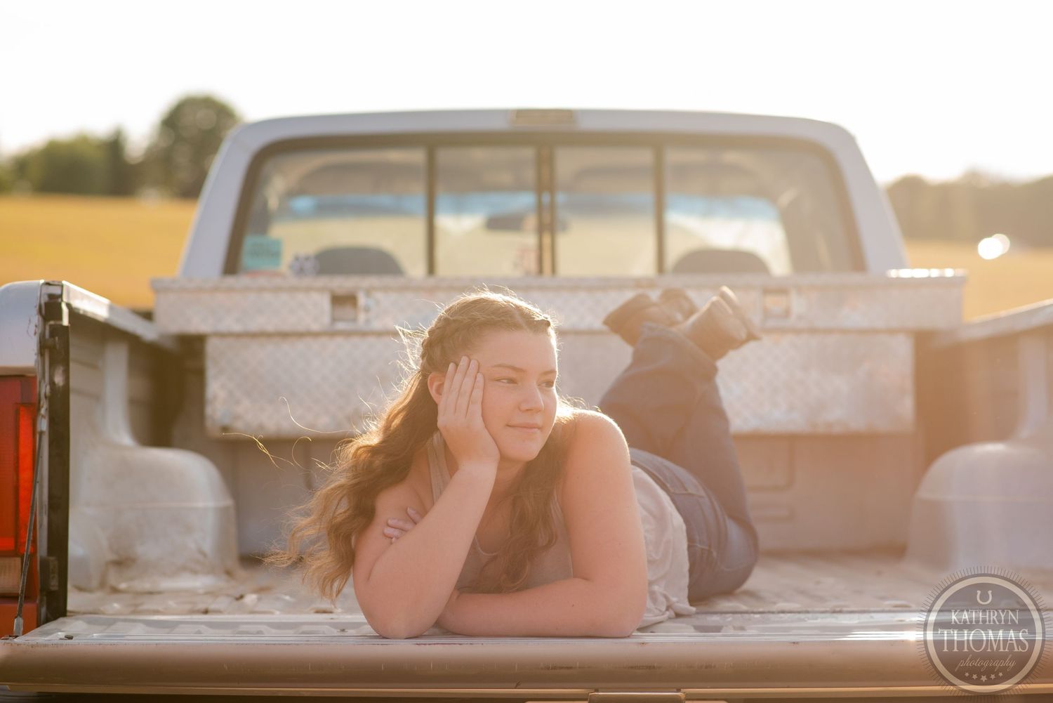 Sunset portrait lying in pickup truck bed with warm golden light.