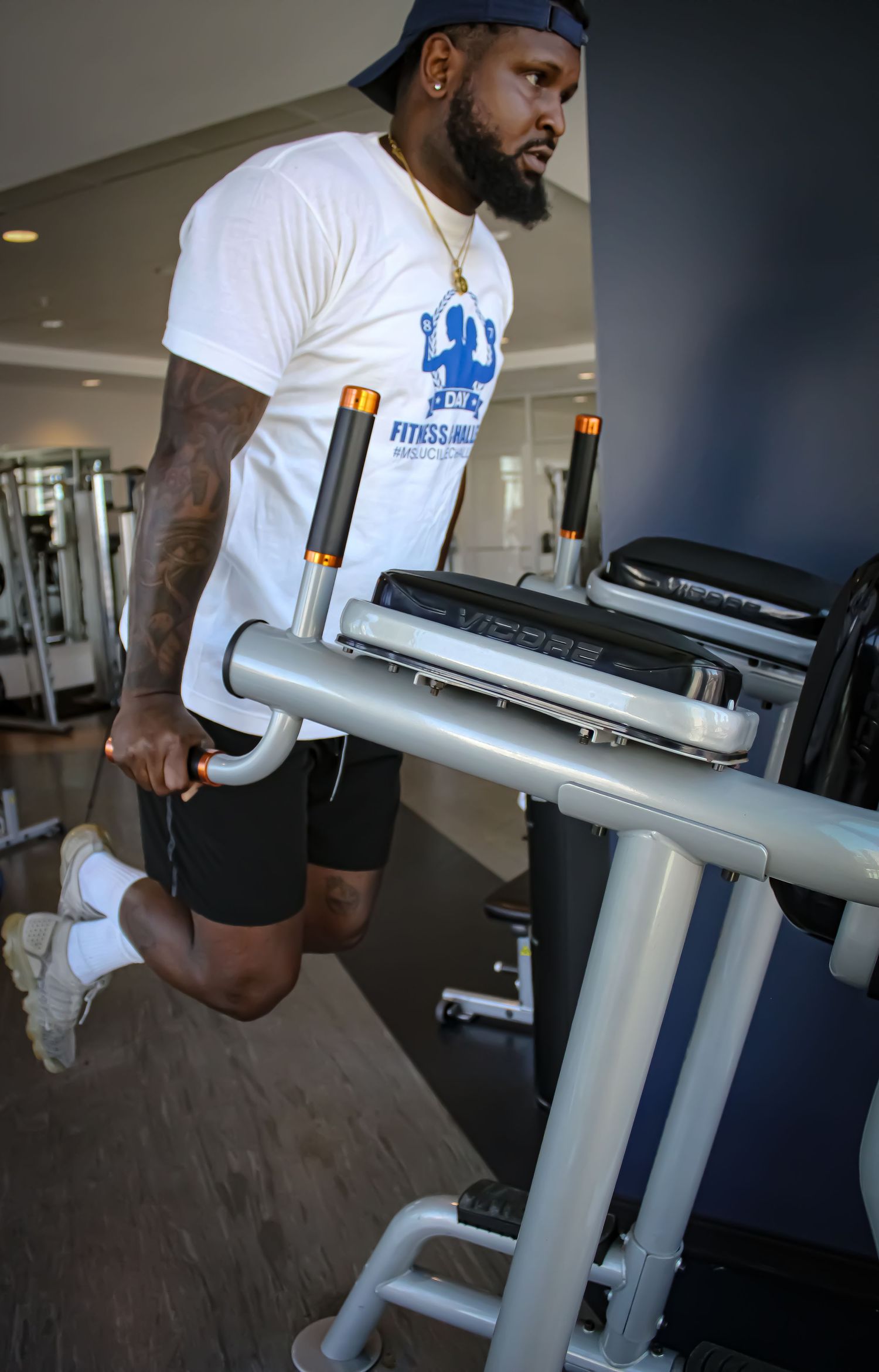 An athlete works out on exercise equipment in a modern gym facility.