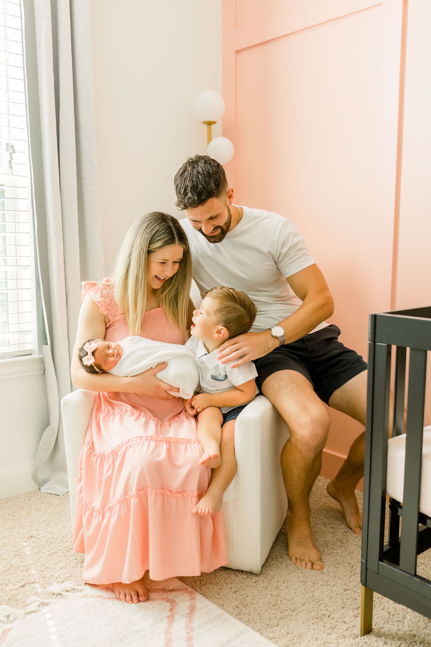 A happy family sharing a tender moment while sitting in their nursery.