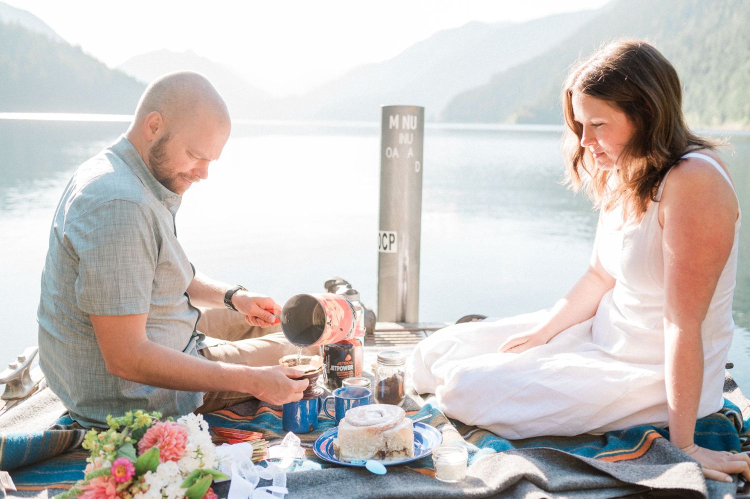 Groom makes coffee during elopement on dock at Lake Crescent. Photo by Pine + Vow