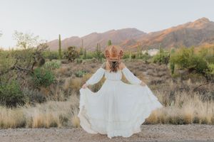White dress flowing in the wind against a desert landscape with mountains.