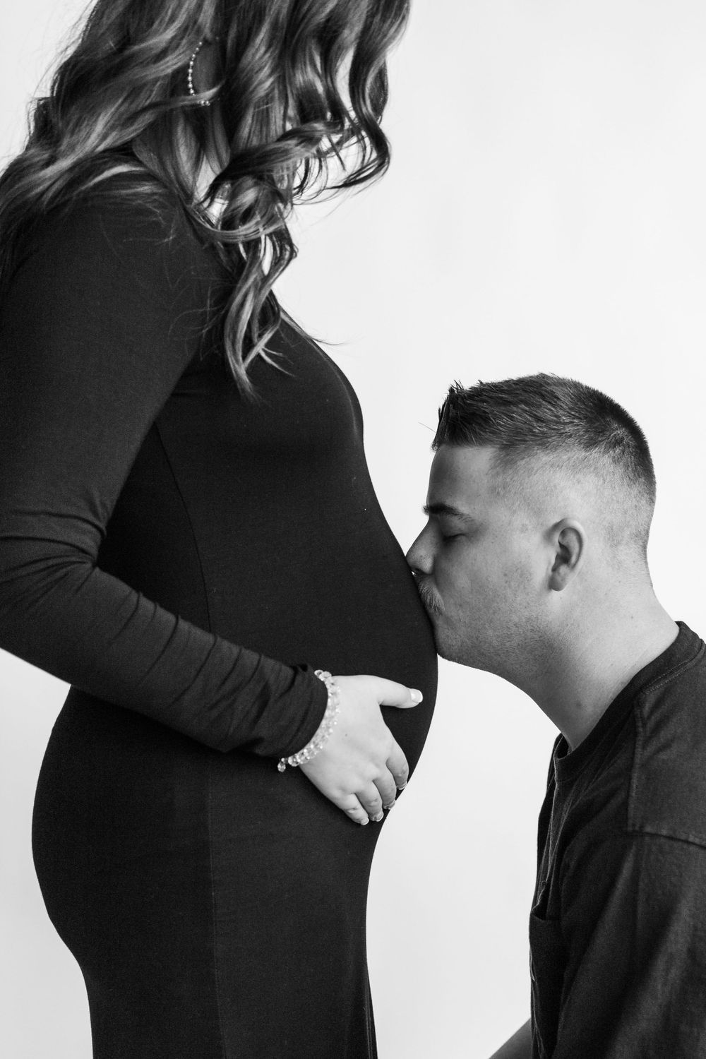 Intimate black and white maternity photo showing tender moment.
