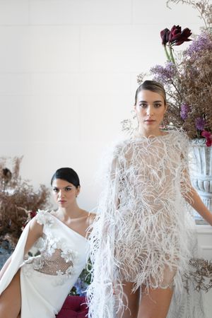 Close-up shots of an avant-garde bridal look with feathered details and floral arrangements.