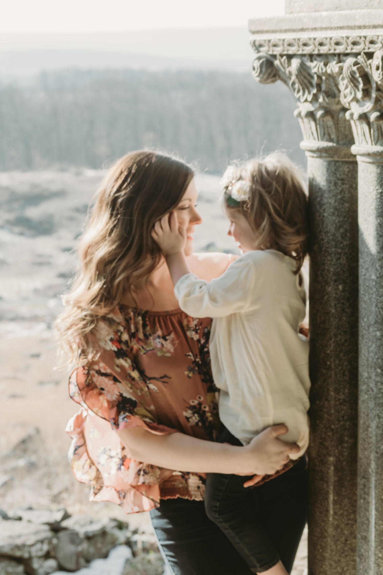 A scenic overlook moment between parent and child against a misty mountain backdrop.
