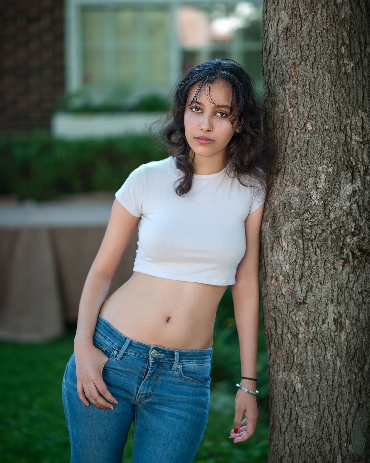 Casual outdoor fashion portraits with white crop top and jeans against tree backdrop.