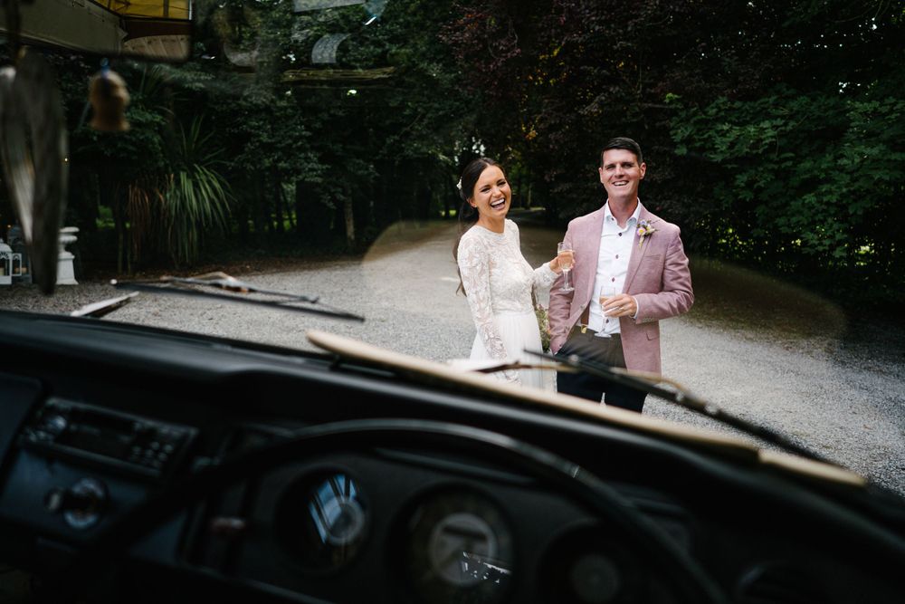 Wedding photo through car windshield with vintage aesthetic.