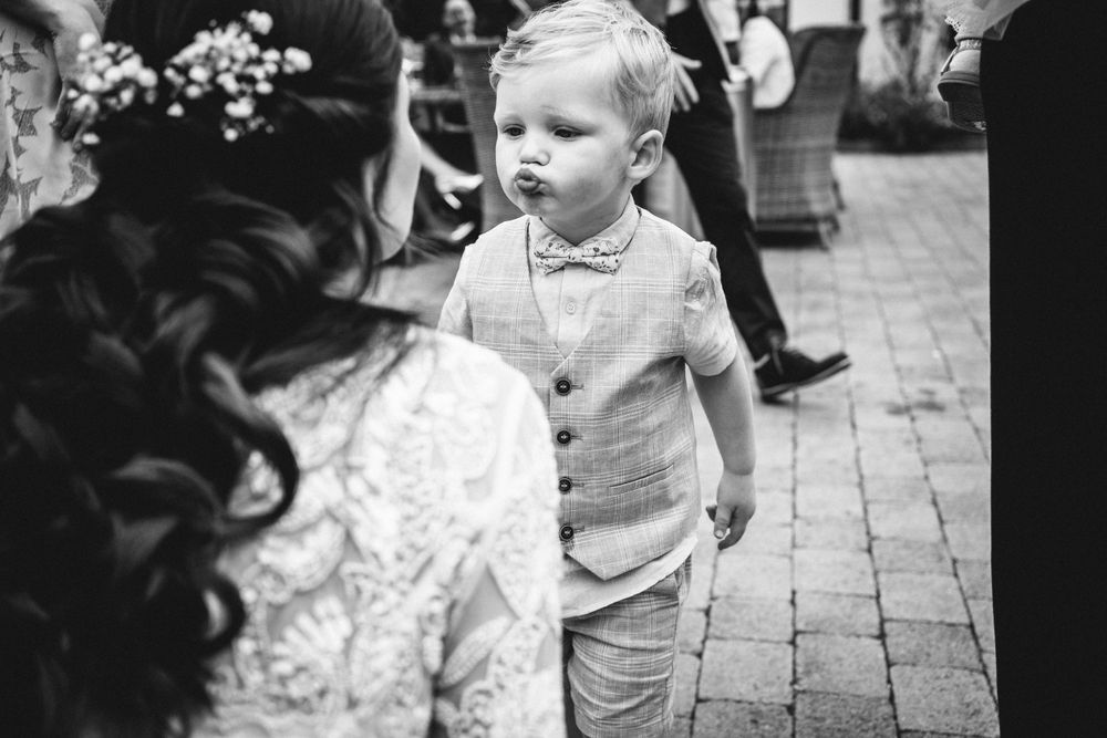 Black and white candid moment of a young child at a formal event.
