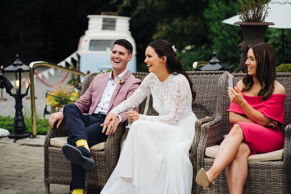 Wedding guests enjoying a casual moment on outdoor patio furniture.