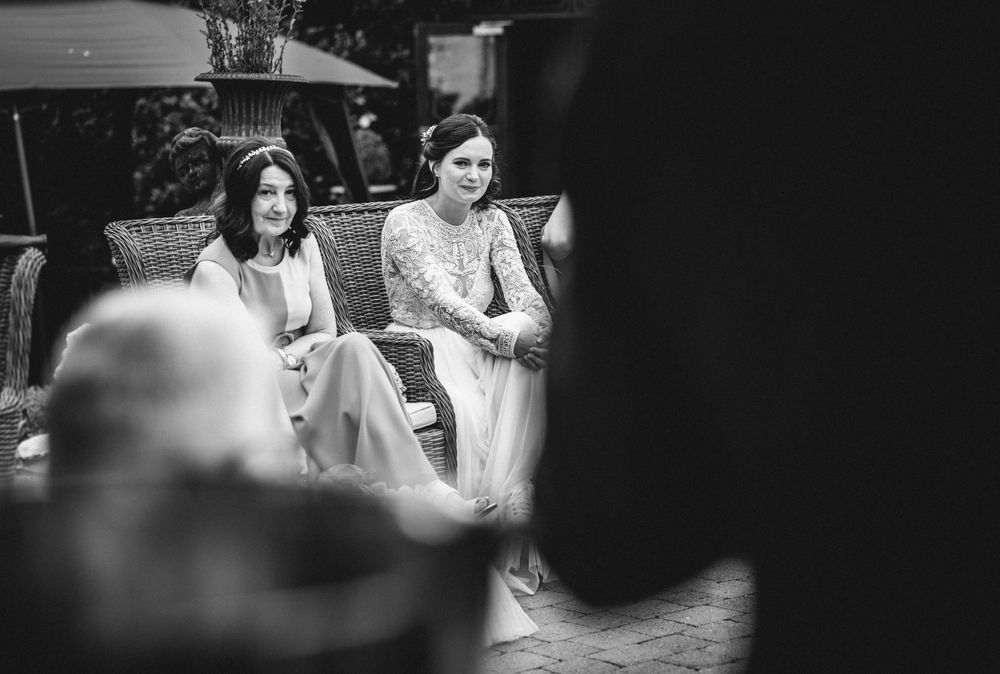 Black and white candid shot of wedding guests during an outdoor celebration.