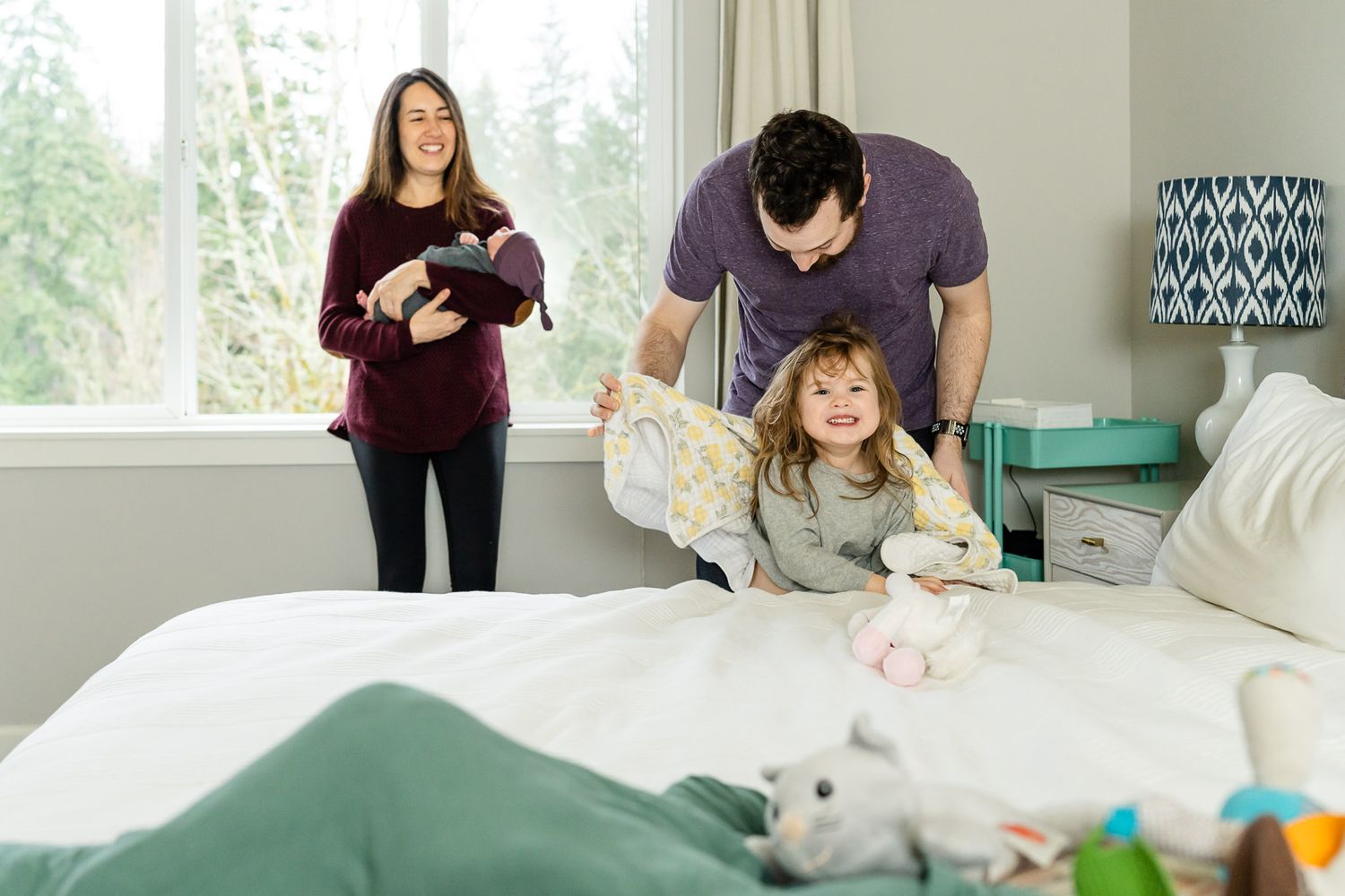 Family laughing together in the master bedroom.