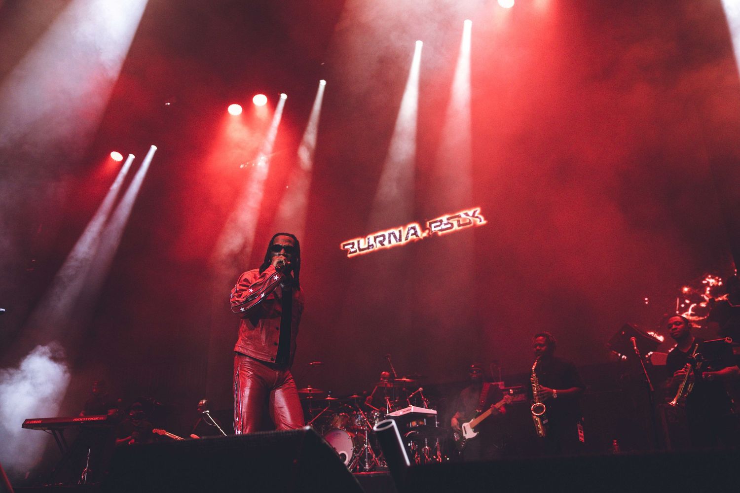 Atmospheric concert stage bathed in red spotlights creating a moody ambiance.