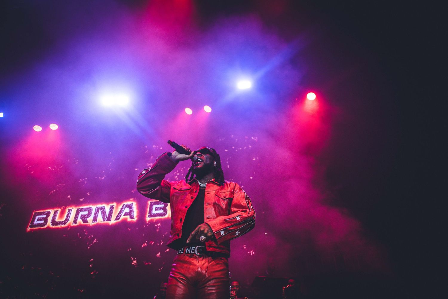 Stage production featuring vibrant purple and red lighting creating a mesmerizing atmosphere.
