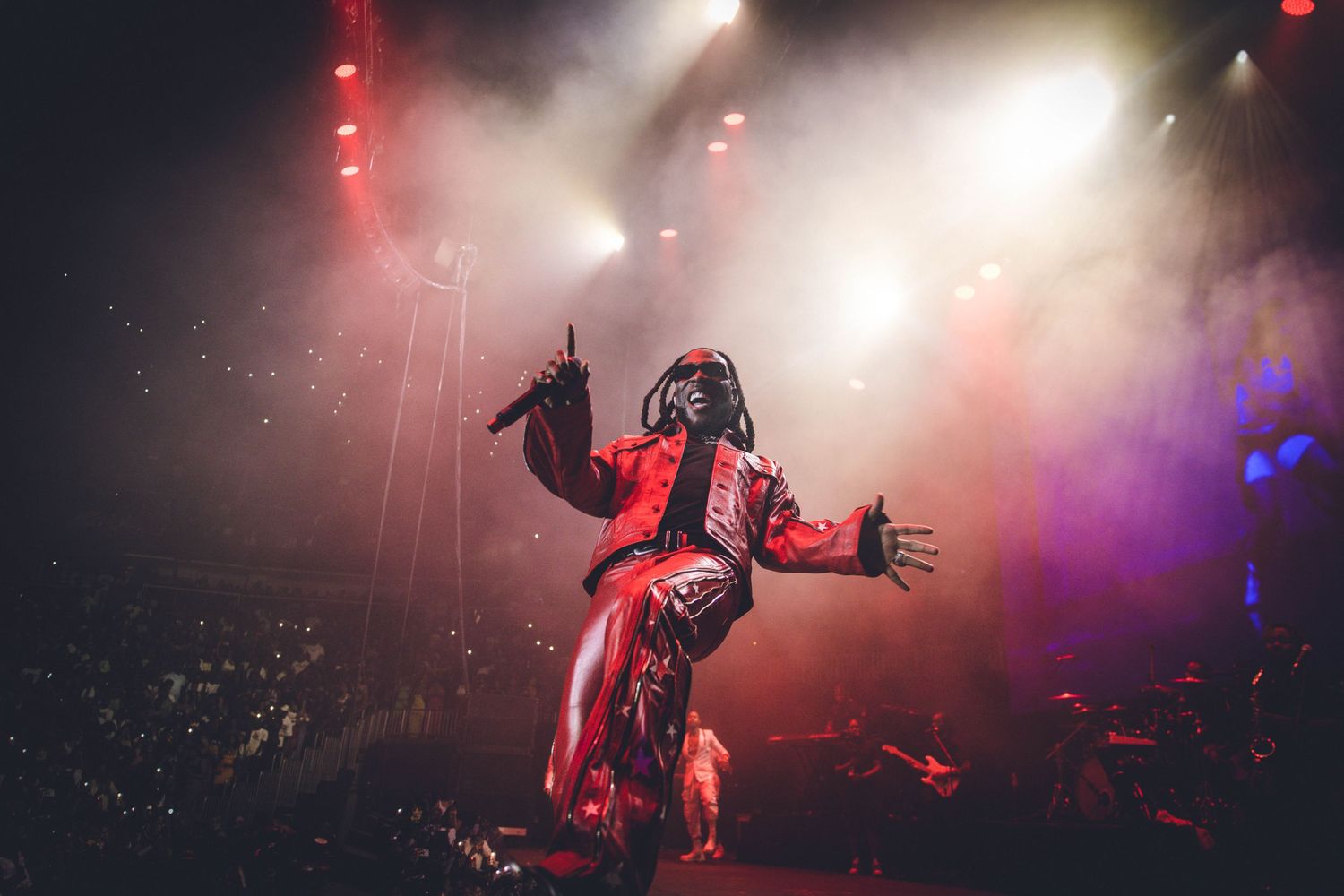 Dynamic concert performance with dramatic spotlights and atmospheric fog effects.