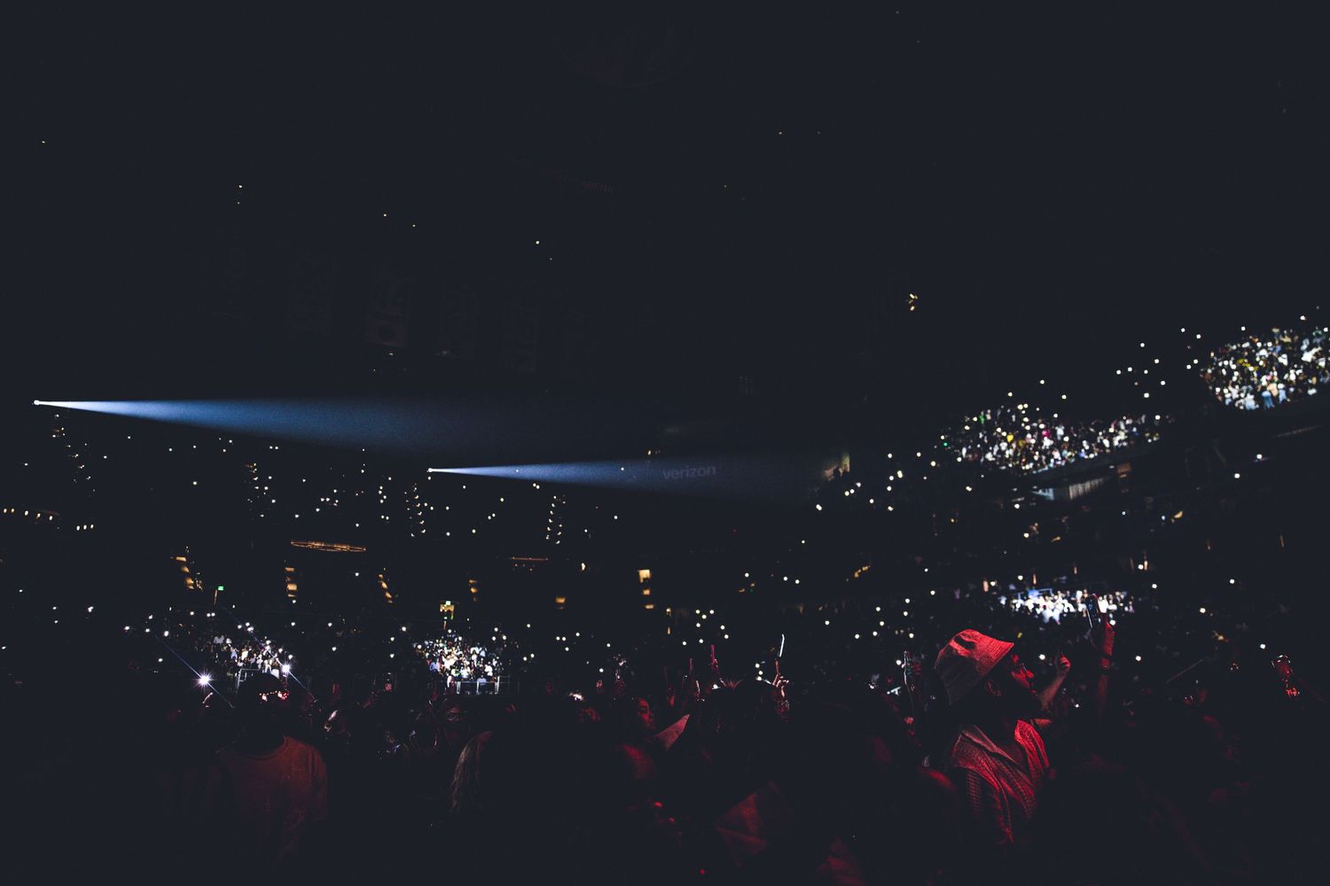 Panoramic nighttime concert shot showing stage lights and distant audience illumination.
