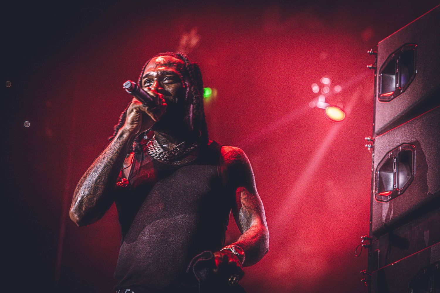 Stage performance captured in deep red lighting with dramatic shadow effects.