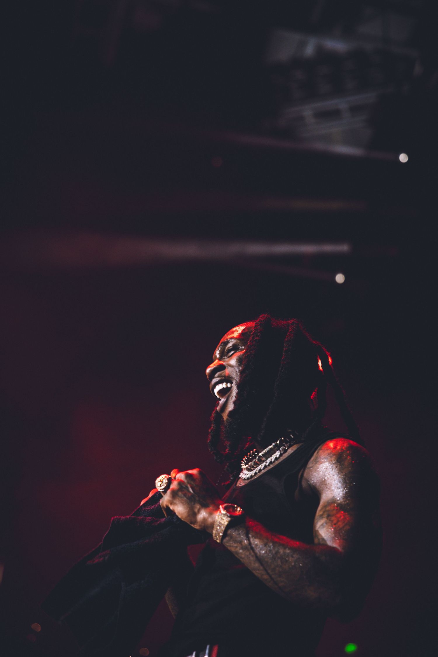Concert scene with dramatic red lighting creating silhouette effect during passionate performance.