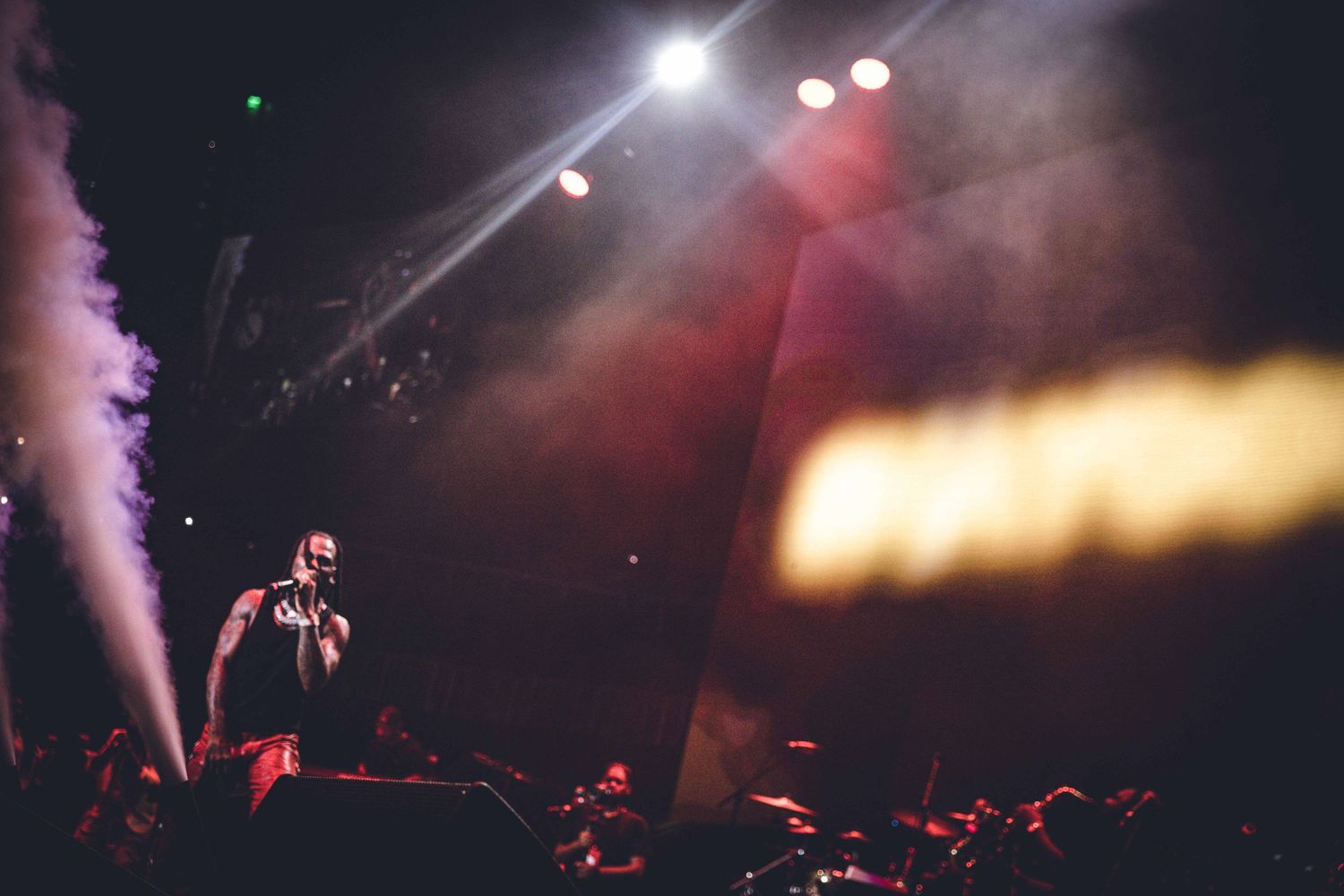 Atmospheric concert shot with smoke effects and bright stage lighting.