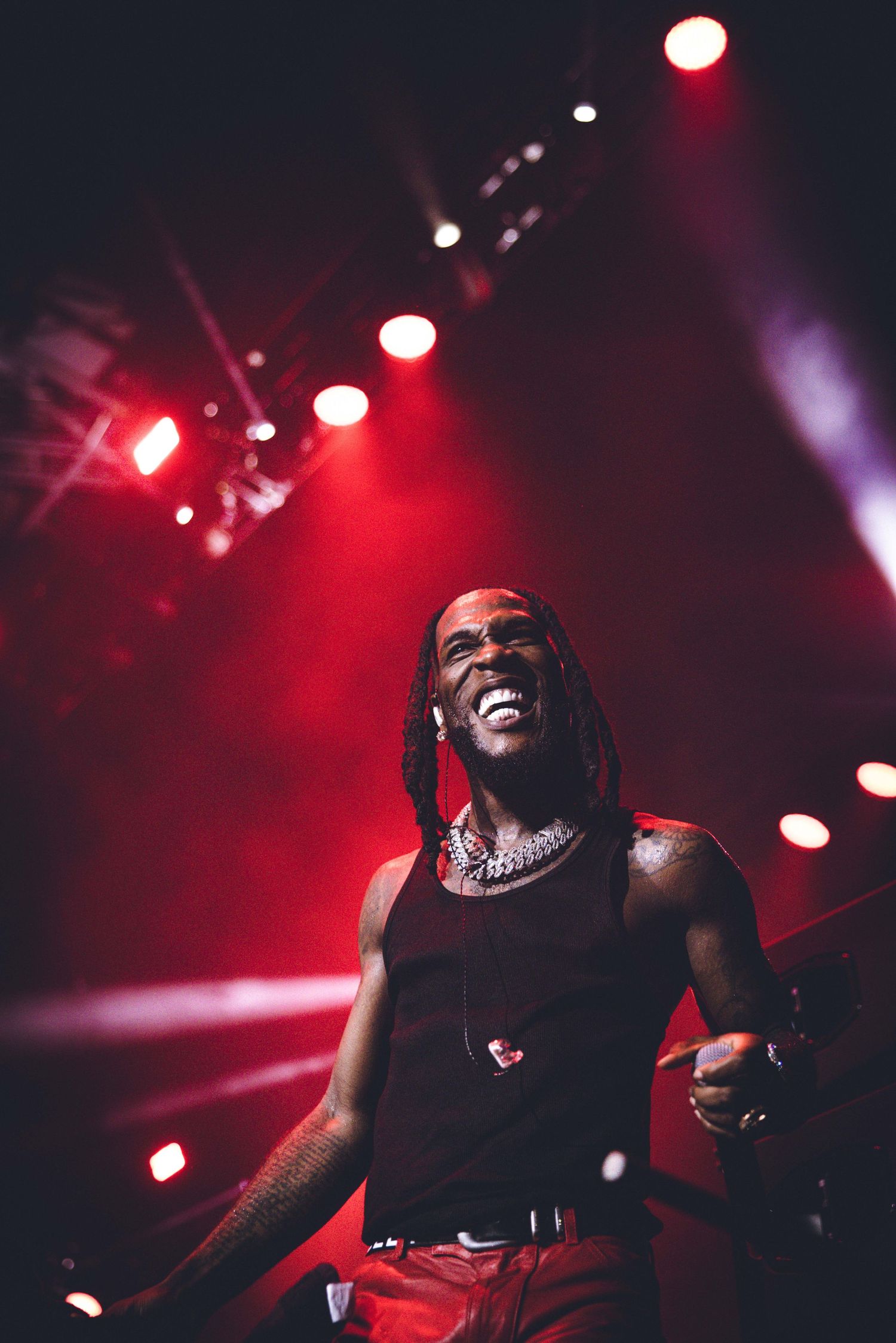 Dynamic performance shot with red stage lighting and spotlights creating dramatic atmosphere.