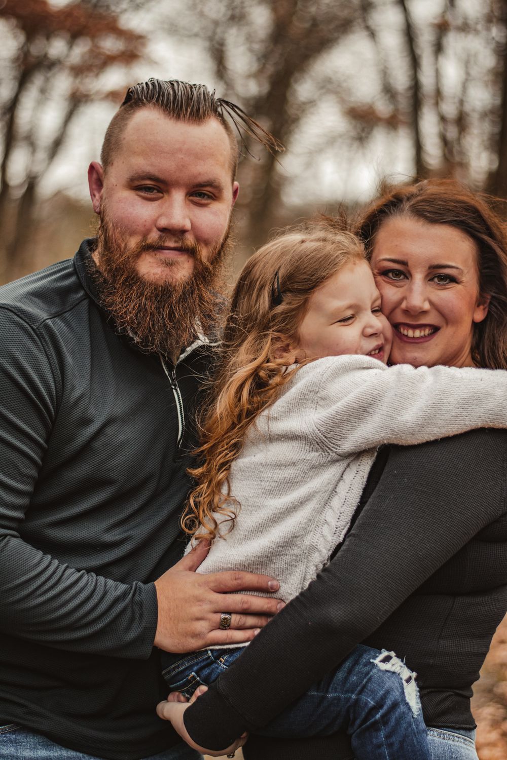 A close-knit family shares an intimate embrace during their autumn photo session.