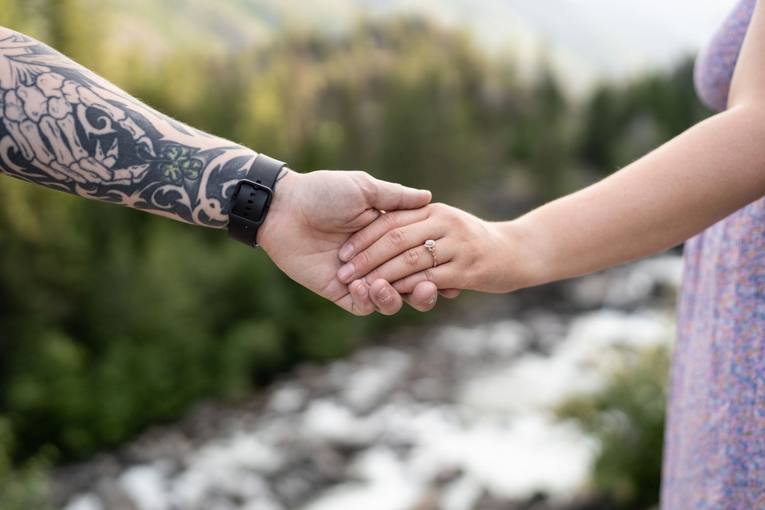 Close-up of two hands holding each other, one with detailed tattoo artwork.