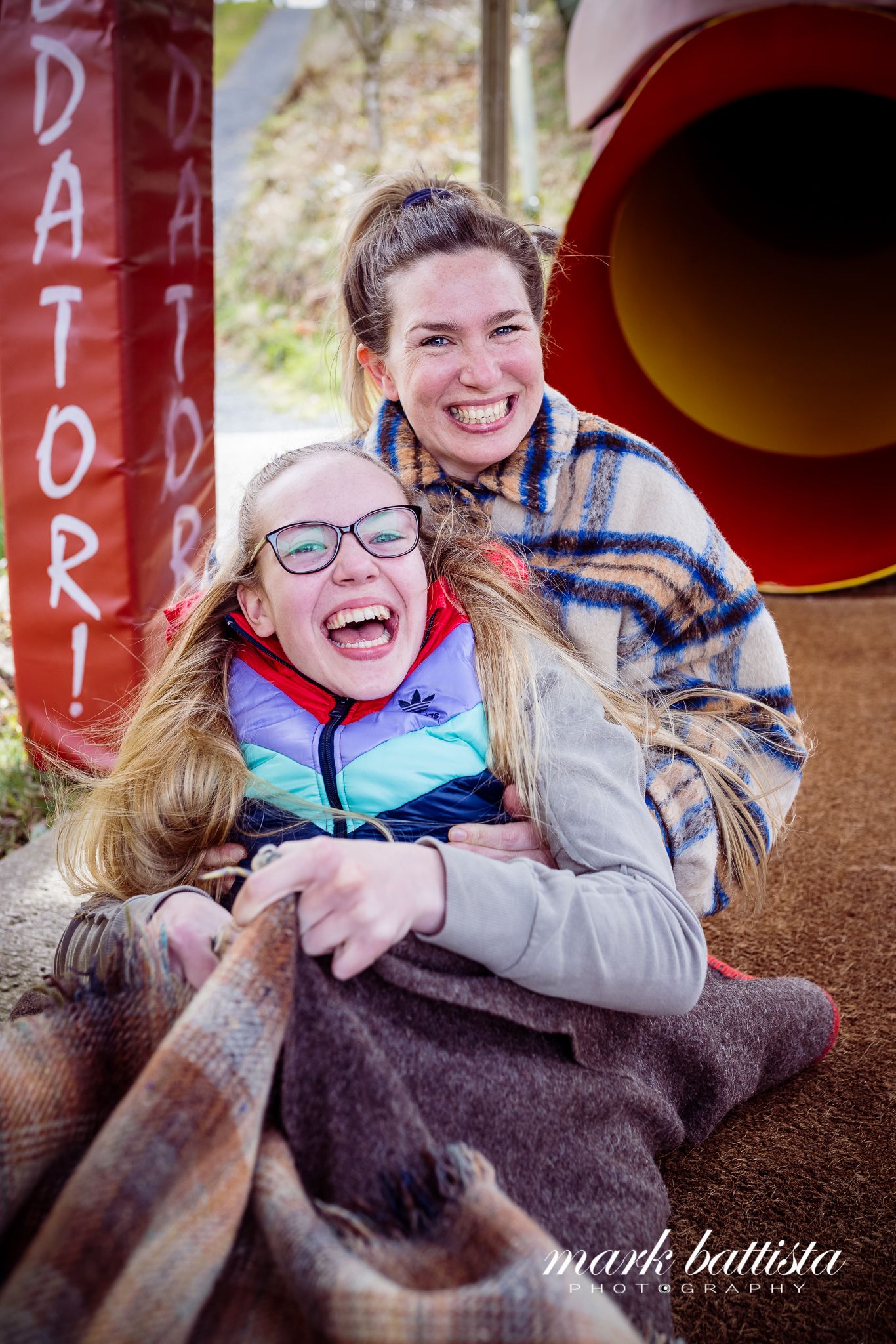 Happy moment captured at an outdoor adaptive sports facility with red equipment visible.