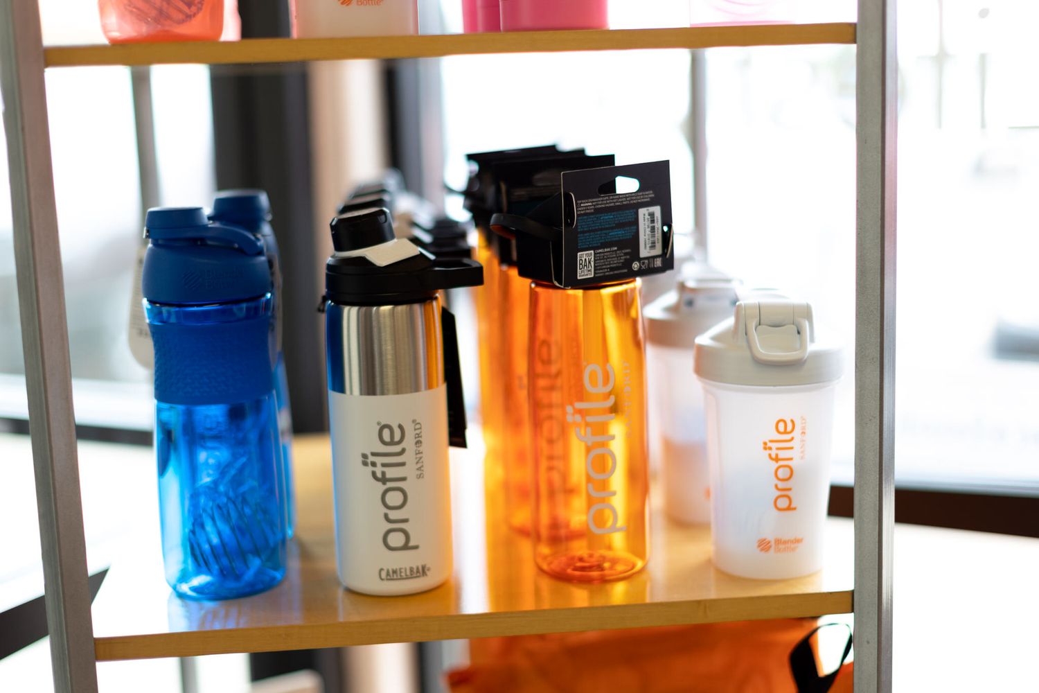 Collection of colorful water bottles and drink containers on store shelf.